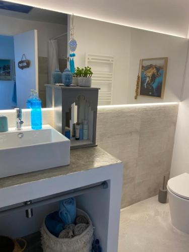 a bathroom with a white sink and a toilet at CASA BOHO your happy place in Calheta in Calheta