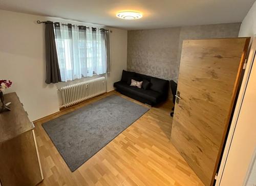 a living room with a black couch and a window at Vasari Home in Meersburg