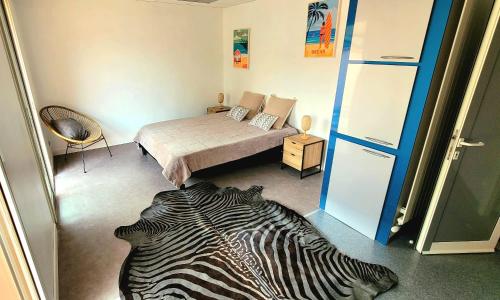 カネ・アン・ルシヨンにあるVilla 5 min de la merのベッド1台とシマウマのプリントラグが備わる客室です。