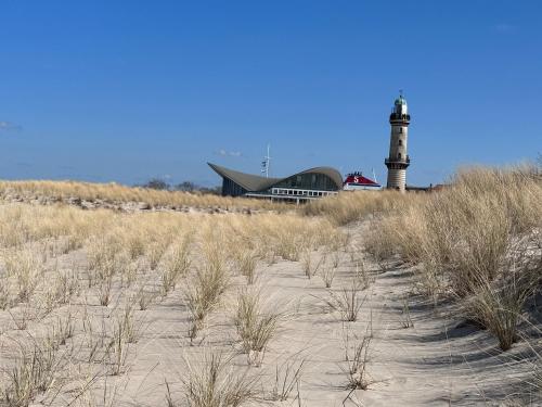 a lighthouse sitting on top of a sandy beach at Meeresbriese Warnemünde in Warnemünde