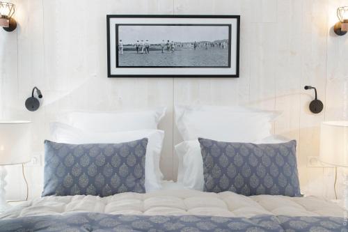 a bed with two pillows and a picture on the wall at La Plonploniere in Aix-en-Issart