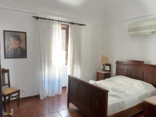 a bedroom with a bed and a chair and a window at Casa Morais Pinto in Reguengos de Monsaraz