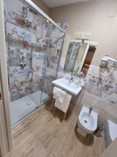 La salle de bains est pourvue d'un lavabo, d'une douche et de toilettes. dans l'établissement LucyBen GuestHouse, à Cascia