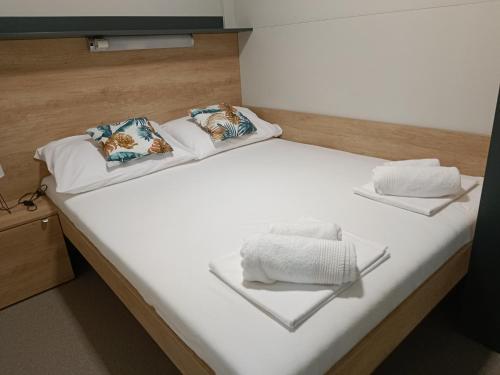 a bed with white sheets and pillows on it at Mobile home Jadre I in Pakoštane