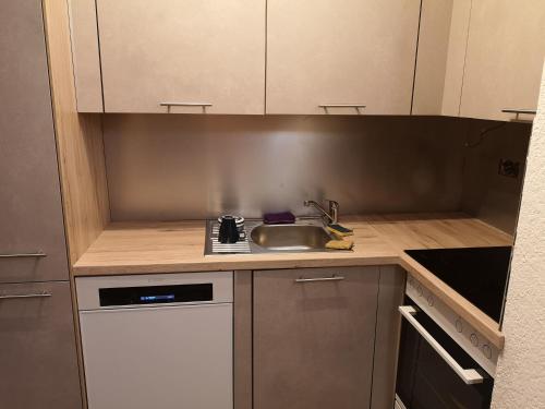 a small kitchen with a sink and a counter at Appartement proche remontées refait à neuf in Crans-Montana