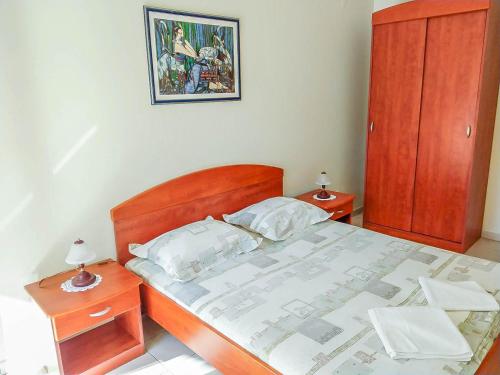 Schlafzimmer mit einem großen Bett mit einem Kopfteil aus Holz in der Unterkunft Keran 2+2 in Podgora