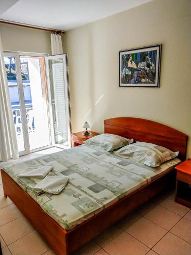 a bed in a bedroom with a large window at Keran 2+2 in Podgora