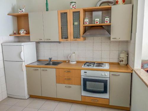 eine kleine Küche mit einem Herd und einem Kühlschrank in der Unterkunft Keran 2+2 in Podgora