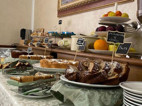 um buffet de pão e produtos de pastelaria numa mesa em Hotel Rex em Praia a Mare