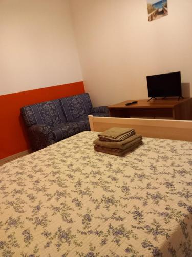 a bedroom with a bed and a desk with a laptop at kola age in Peschiera del Garda