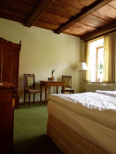 a bedroom with a bed and a table and chairs at Hotel und Gasthof Dreibeiniger Hund in Görlitz