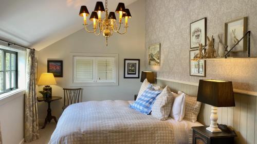 a bedroom with a bed and a chandelier at The Barn at Killin B&B in Ohau