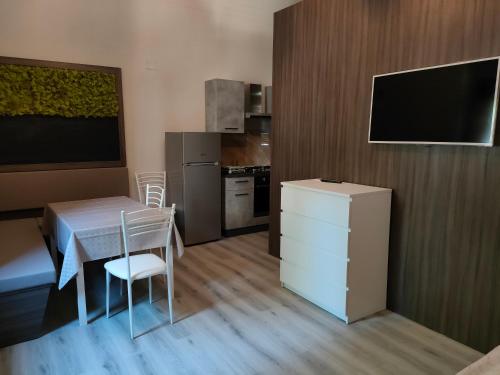 eine kleine Küche mit einem Tisch und einem TV in einem Zimmer in der Unterkunft Cilento relax San Marco Castellabate JML in San Marco di Castellabate