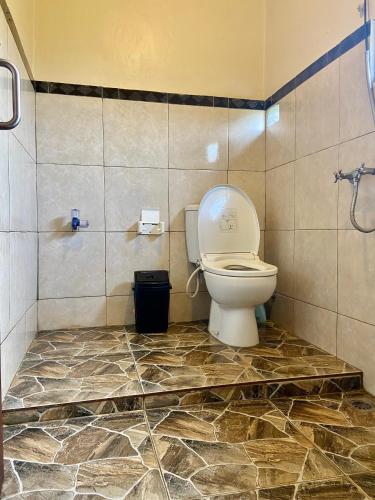 a bathroom with a toilet in a tiled room at D'JERO HomeStay in Ubud