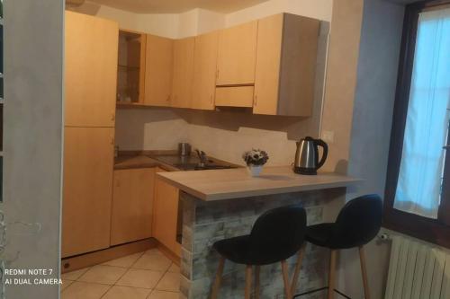 a kitchen with a counter and two stools in a kitchen at Appartamento Le Rondini nel centro di Intra in Intra