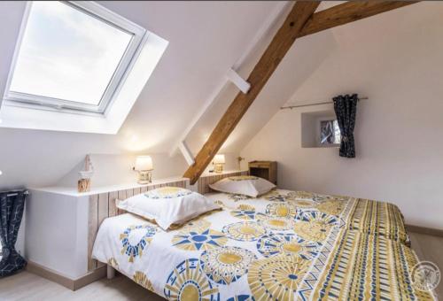 - une chambre mansardée avec un grand lit dans l'établissement Gîte « Les Embruns », à Cosqueville