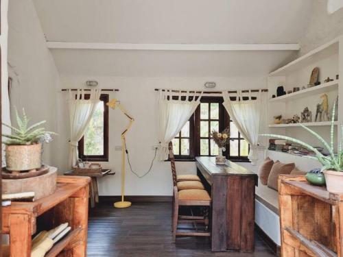 - un salon avec une table, des chaises et des fenêtres dans l'établissement Naturetalk Farmstay 3 bedrooms, à Ban Don