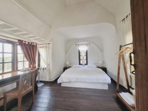 Schlafzimmer mit einem weißen Bett und einem Schreibtisch in der Unterkunft Naturetalk Farmstay 3 bedrooms in Ban Don