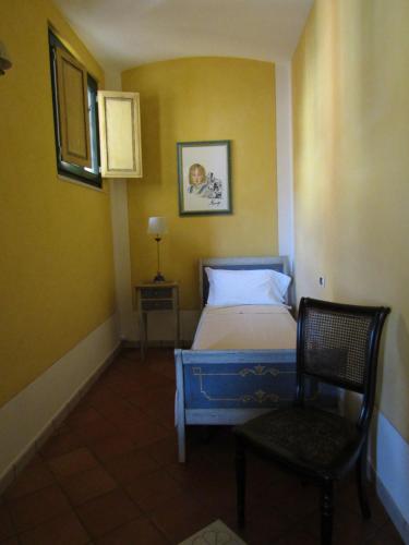 a small bedroom with a bed and a chair at Antichi Feudi Dimora D'Epoca in Teggiano