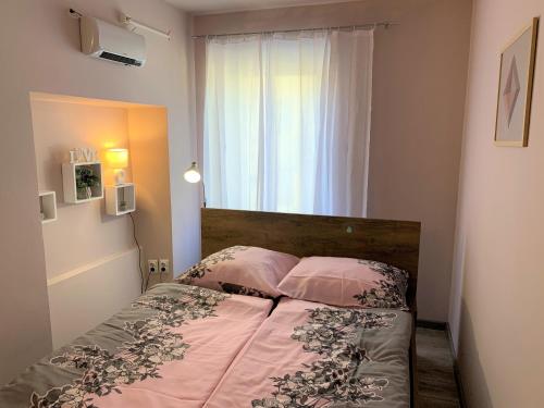 una camera da letto con un letto con due cuscini e una finestra di Apartment Lupo a Vodnjan (Dignano)