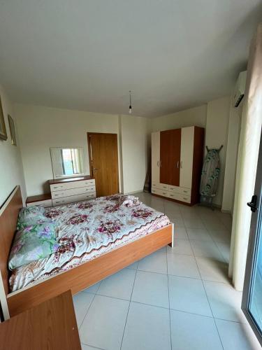 een slaapkamer met een bed in het midden van een kamer bij Lami Apartment rana e hedhur in Shëngjin