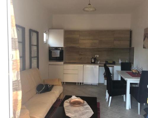 a living room with a couch and a table and a kitchen at Macko, Apartmani in Tivat