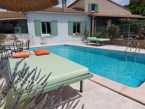 - une piscine avec un lit en face d'une maison dans l'établissement villa la Prairie, à Boulbon