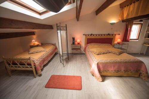 1 dormitorio con 2 camas y alfombra roja en villa la Prairie, en Boulbon