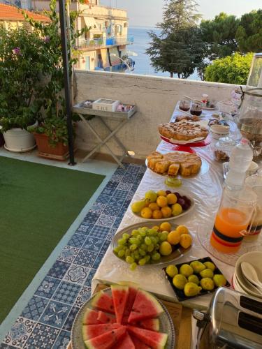 a table with food and fruit on a balcony at La Dependance ApartHotel Scilla in Scilla