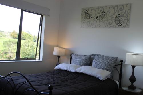 um quarto com uma cama e uma janela grande em McLaren Lake View em Tauranga