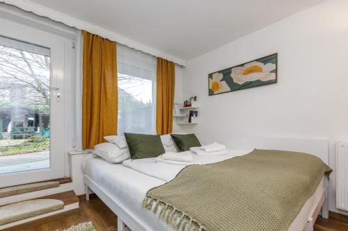 biała sypialnia z łóżkiem i oknem w obiekcie Origo Vendégház w Hévízie