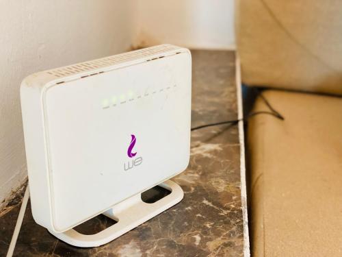 a white router sitting on the floor next to a box at Blue Villa in Lighthouse in Dahab