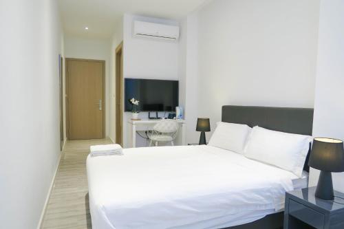 - une chambre avec un grand lit blanc et un bureau dans l'établissement Comfy Studio 5 by ReCharge, à Singapour