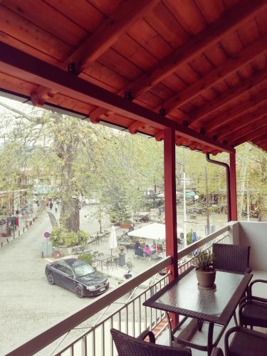 a balcony with a table and a car on a street at Ξενωνας Κάρμα in Órma