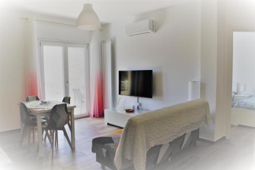 a living room with a table and a bedroom at Zefiro Holiday Home in Agropoli