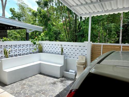 un banc blanc dans une arrière-cour avec pergola dans l'établissement rindoe jogja holiday home, à Yogyakarta