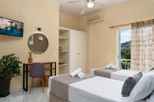 a bedroom with two beds and a window at Villa Dionysios in Keri