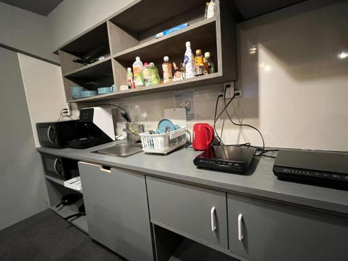 a kitchen with a counter with a sink and a microwave at Rhodes Otsuka Hotel in Tokyo