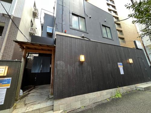 a building with a black wall and lights on it at Rhodes Otsuka Hotel in Tokyo