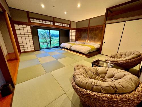 una grande camera con due letti e una sedia di 那古井館別邸　玉響[TAMAYURA] a Tamana