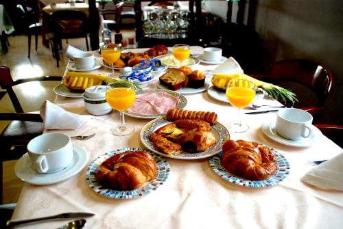 a table with plates of pastries and glasses of orange juice at Hotel Doña Jimena in Villarcayo