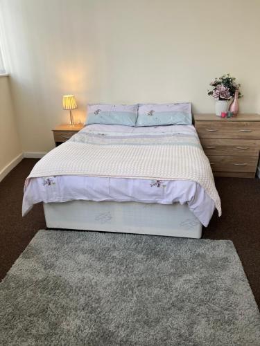 um quarto com uma cama grande com lençóis e almofadas roxos em Two Bed Town Apartment em Rotherham