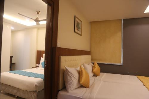 Un dormitorio con dos camas con almohadas amarillas. en Hotel The Prime, en Hyderabad