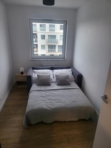 a bed with two pillows in a room with a window at Apartament MAJA (przy Aquaparku w Redzie) in Rumia