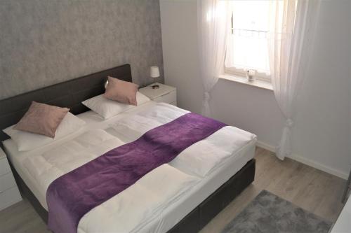 a bedroom with a large bed with a purple blanket at Auszeitoase in Olsberg