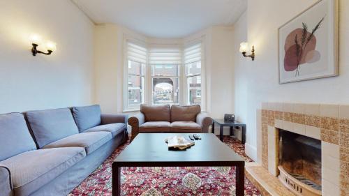 sala de estar con sofá y chimenea en Cheerful 4 Bedroom Victorian house with back courtyard en Londres