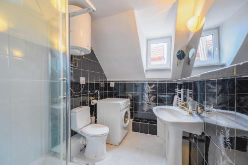 a bathroom with a toilet and a sink and a shower at Zielony by OneApartments in Sopot