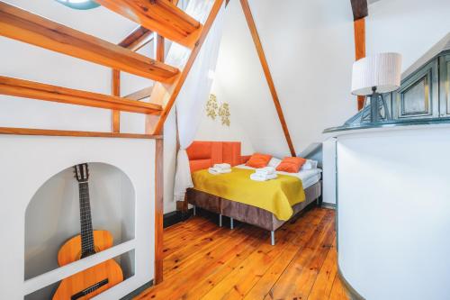 a bedroom with a bed and a guitar in a room at Zielony by OneApartments in Sopot