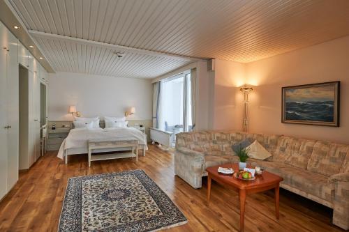 Badhotel Sternhagen في كوكسهافن: غرفة معيشة مع أريكة وسرير