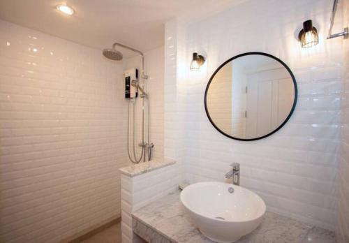 a white bathroom with a sink and a mirror at Modern condo in Nimman with panoramic city view in Chiang Mai